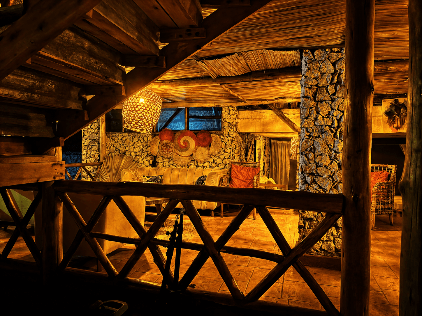 The Elephant Oasis lodge interior at night, warm lighting and stone walls, Murchison Falls Uganda
